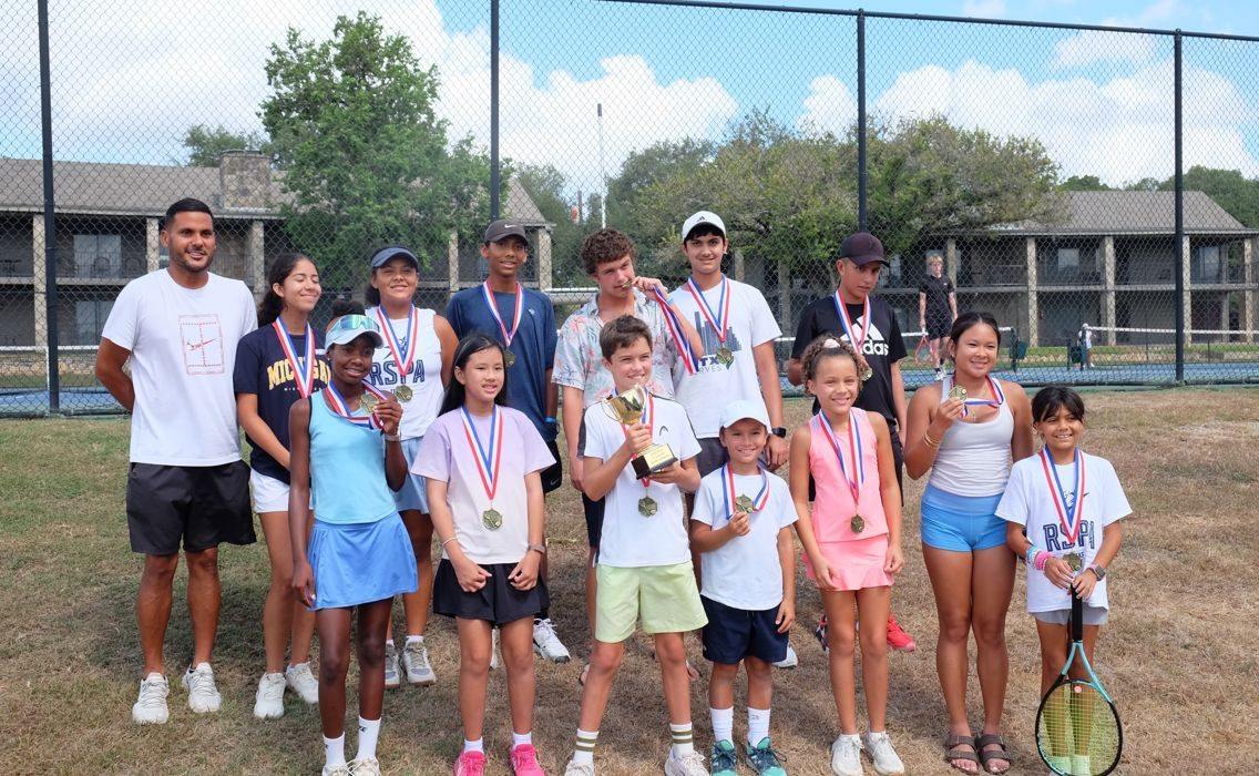 Junior Gran Prix medallists with their coach after a circuit event