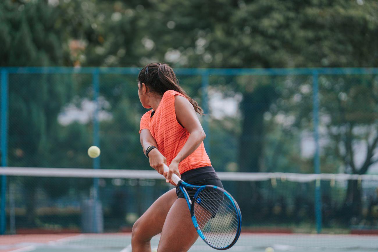 A player hitting a two-handed backhand during a match