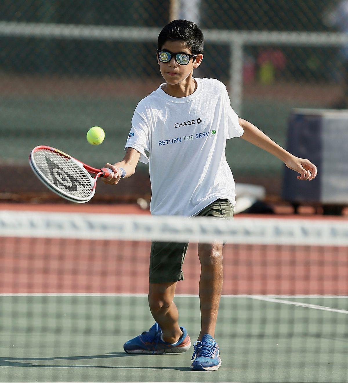 A junior player hitting a forehand in competition