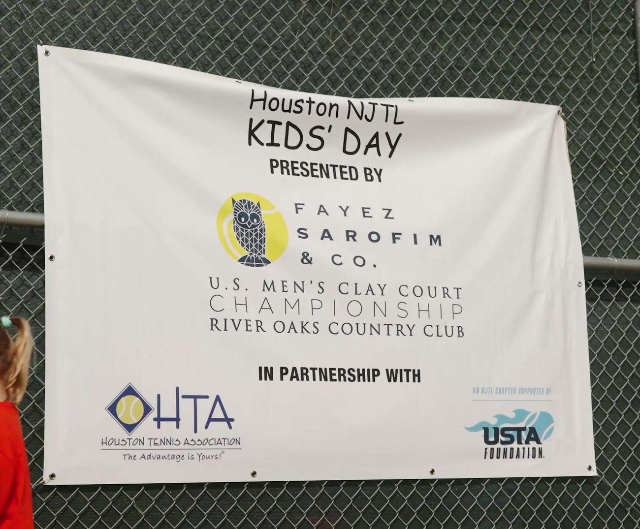 Houston NJTL Kids&rsquo; Day sponsor banner: presented by Fayez Sarofim & Co., U.S. Men&rsquo;s Clay Court Championship at River Oaks Country Club, in partnership with the Houston Tennis Association and USTA Foundation