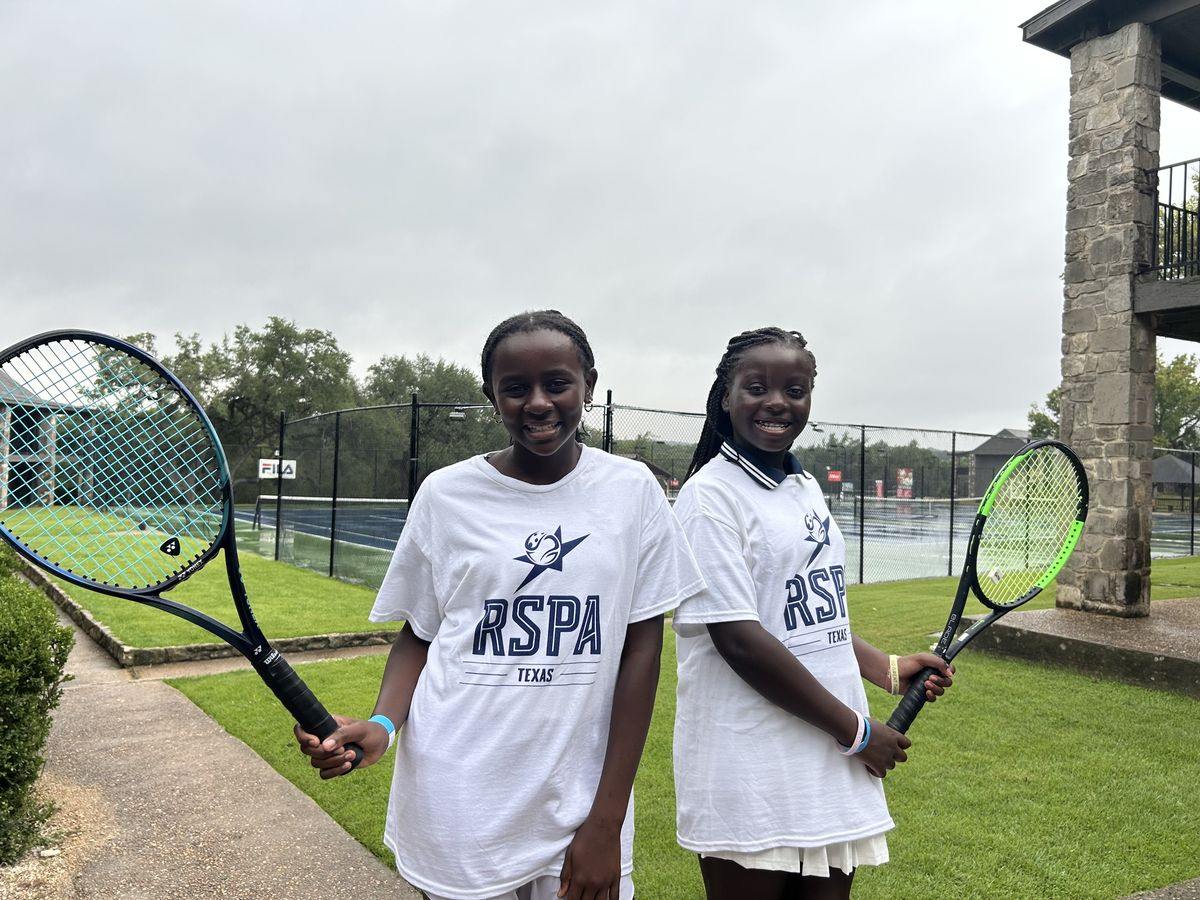 Two junior players with racquets after a session