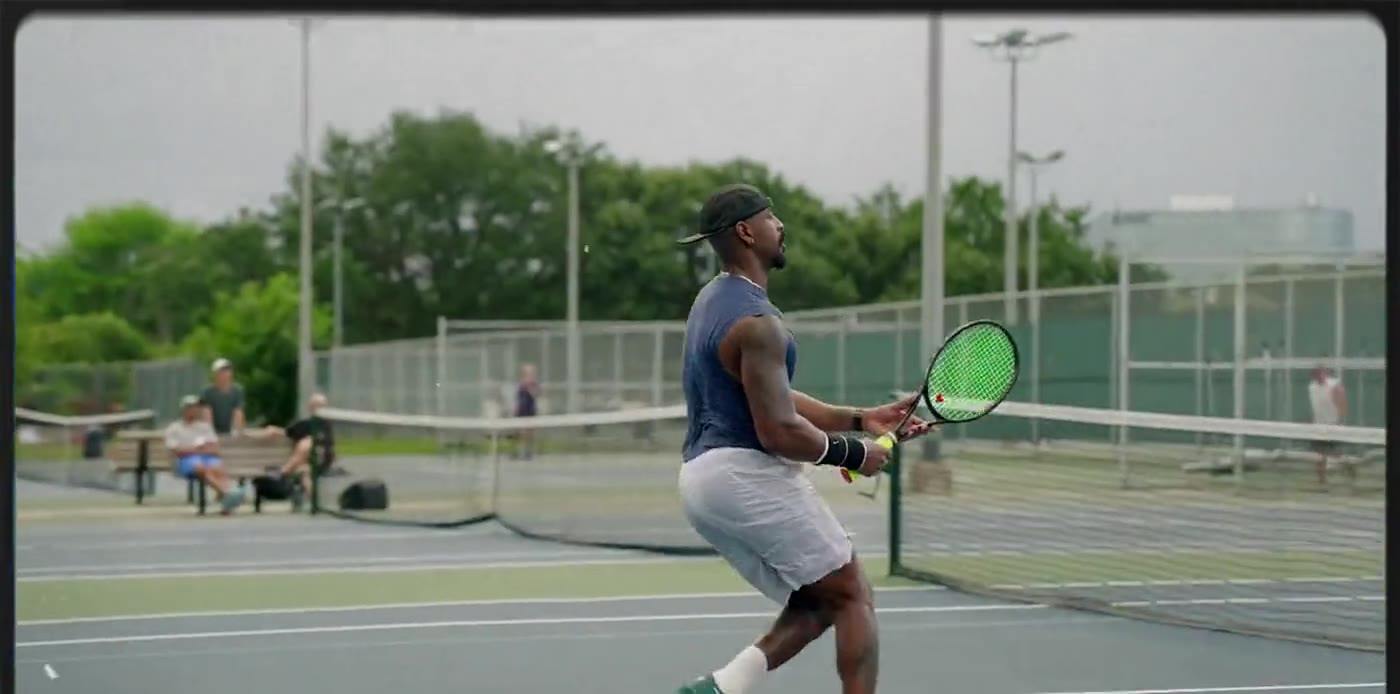 An adult player preparing to serve on a Houston public court